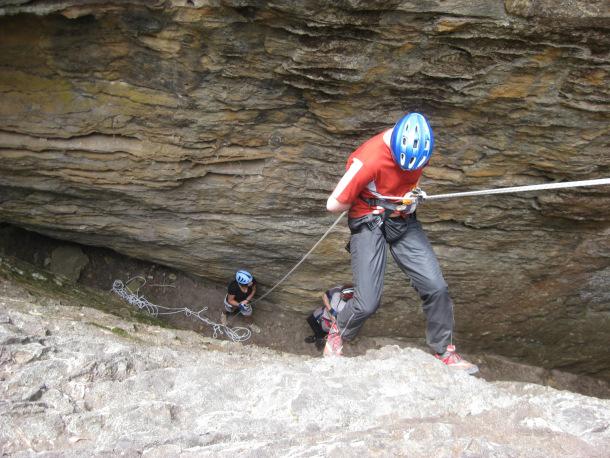 An only too common sight: the belayer is holding her hands low, not looking at the abseiler and talking to a bystander instead. She would hardly be able to stop the abseiler in time if anything were to happen.